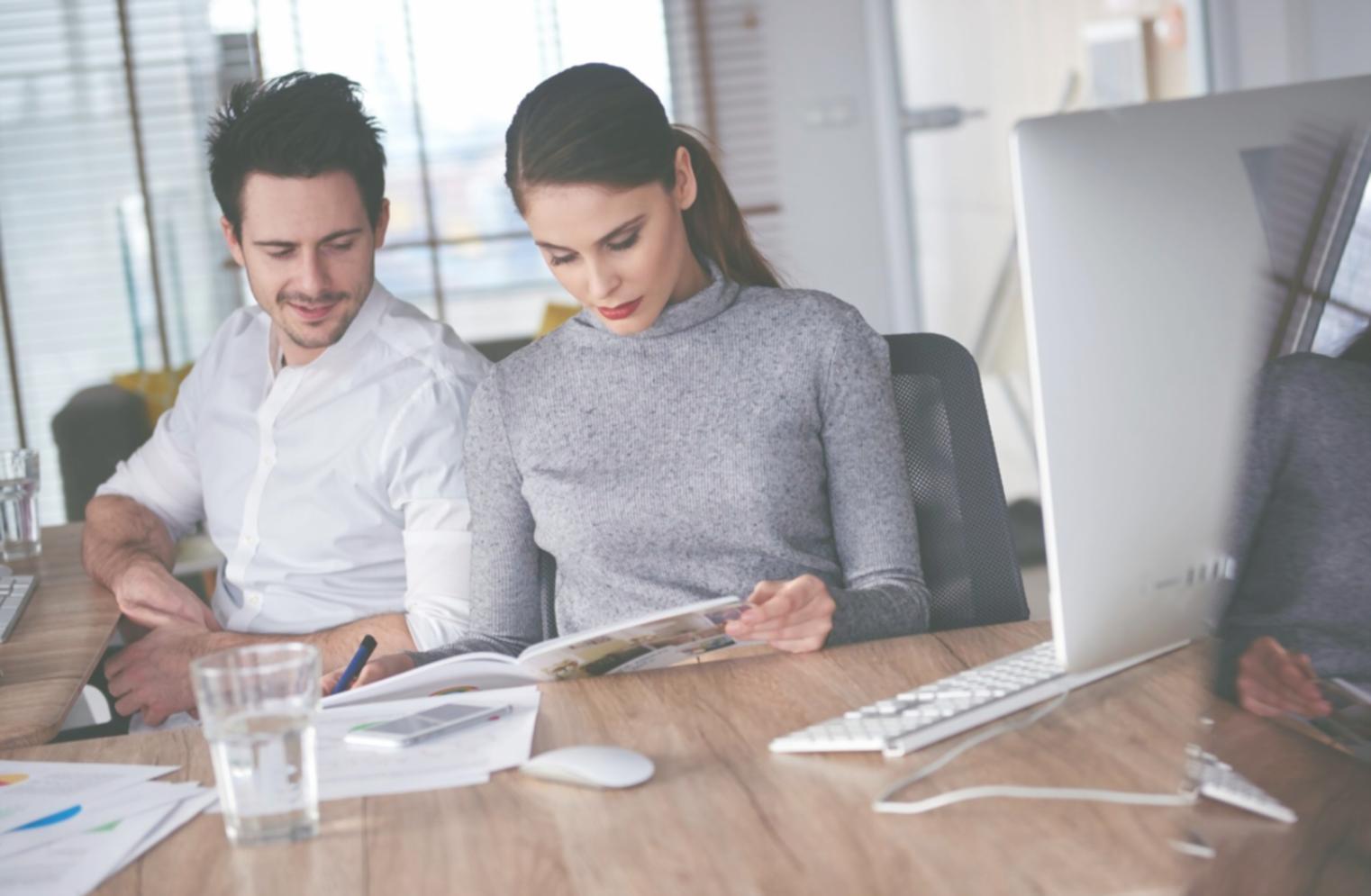 Consultor financiero analizando documentos durante una sesión personalizada de planificación